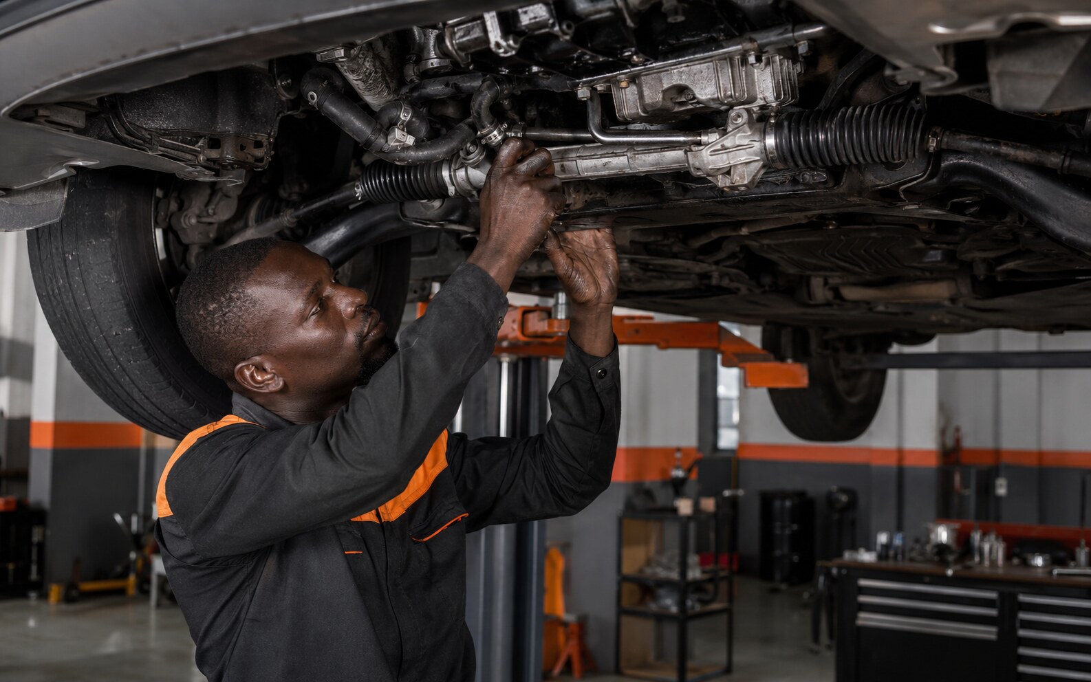 Technician servicing a vehicle steering rack and power-steering system
